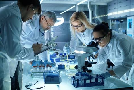 A group of people in lab coats working on some things.